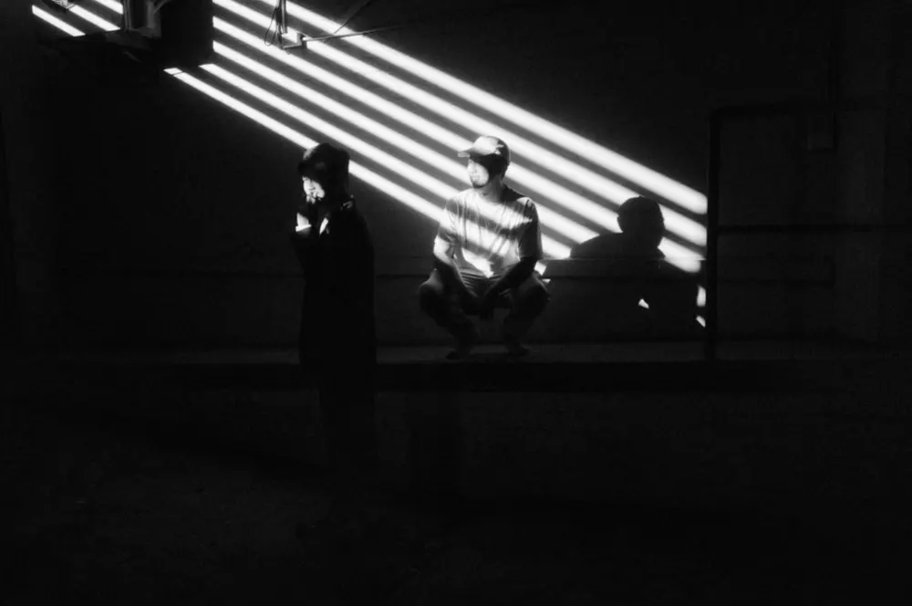 Black and white behind-the-scenes shot of Jason Tran directing on set